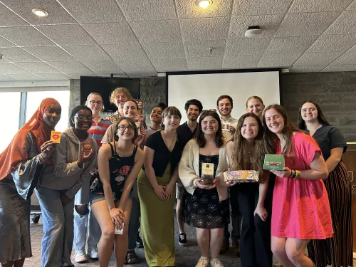 A group of students pose holding awards and documents