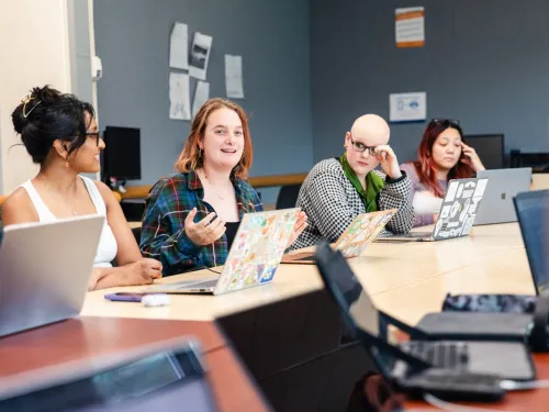 group of students talk around a table