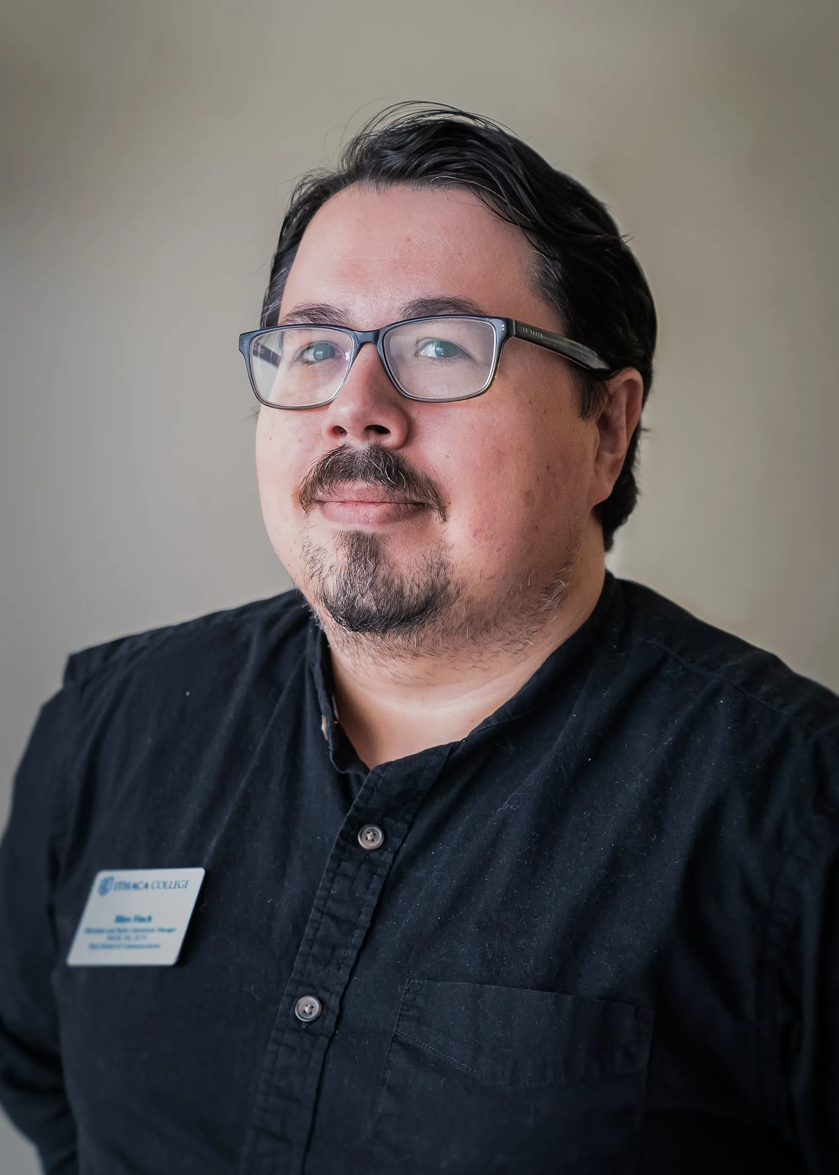 A headshot of Rhys Finch wearing a black shirt